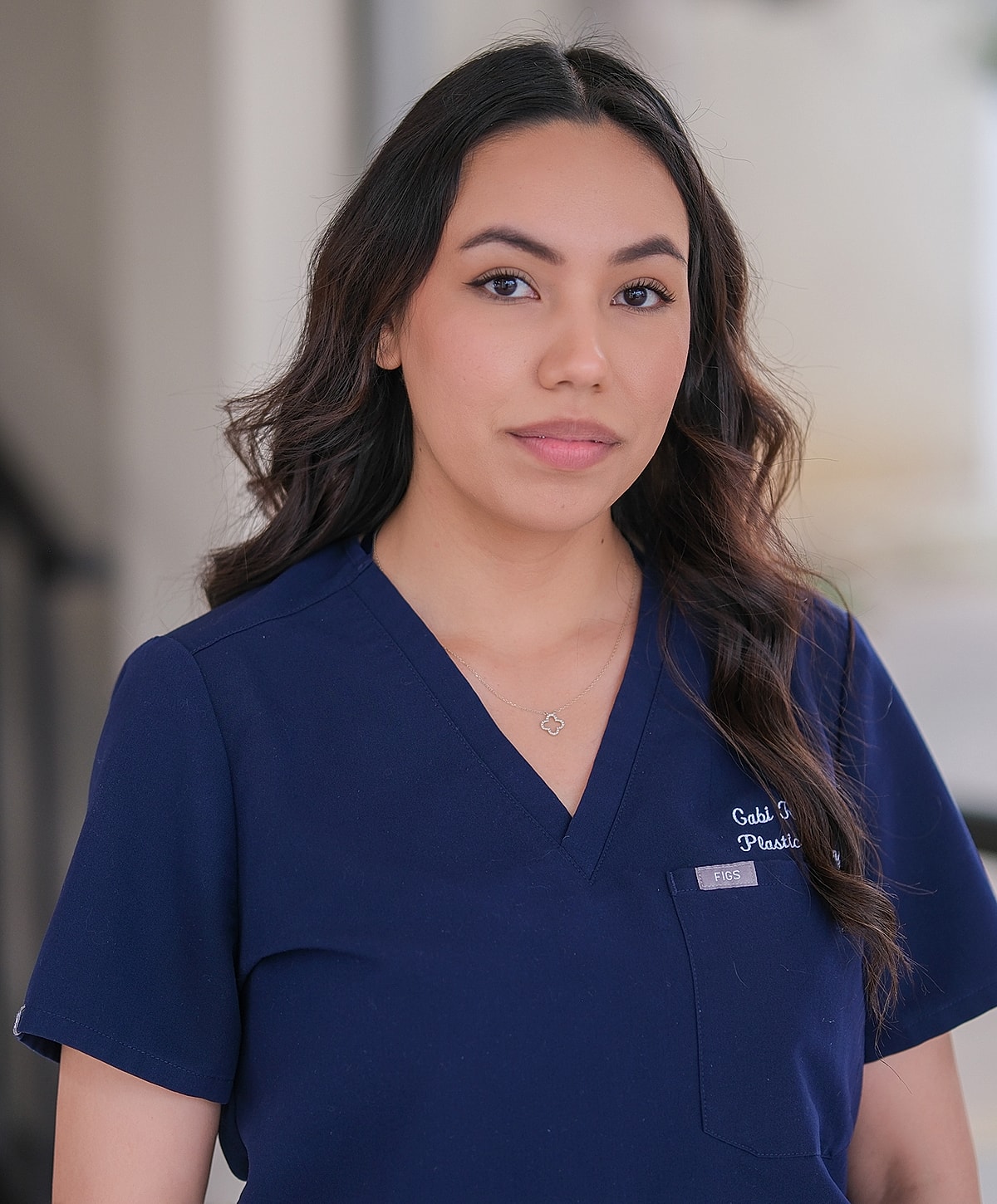 Female healthcare professional in navy scrubs.