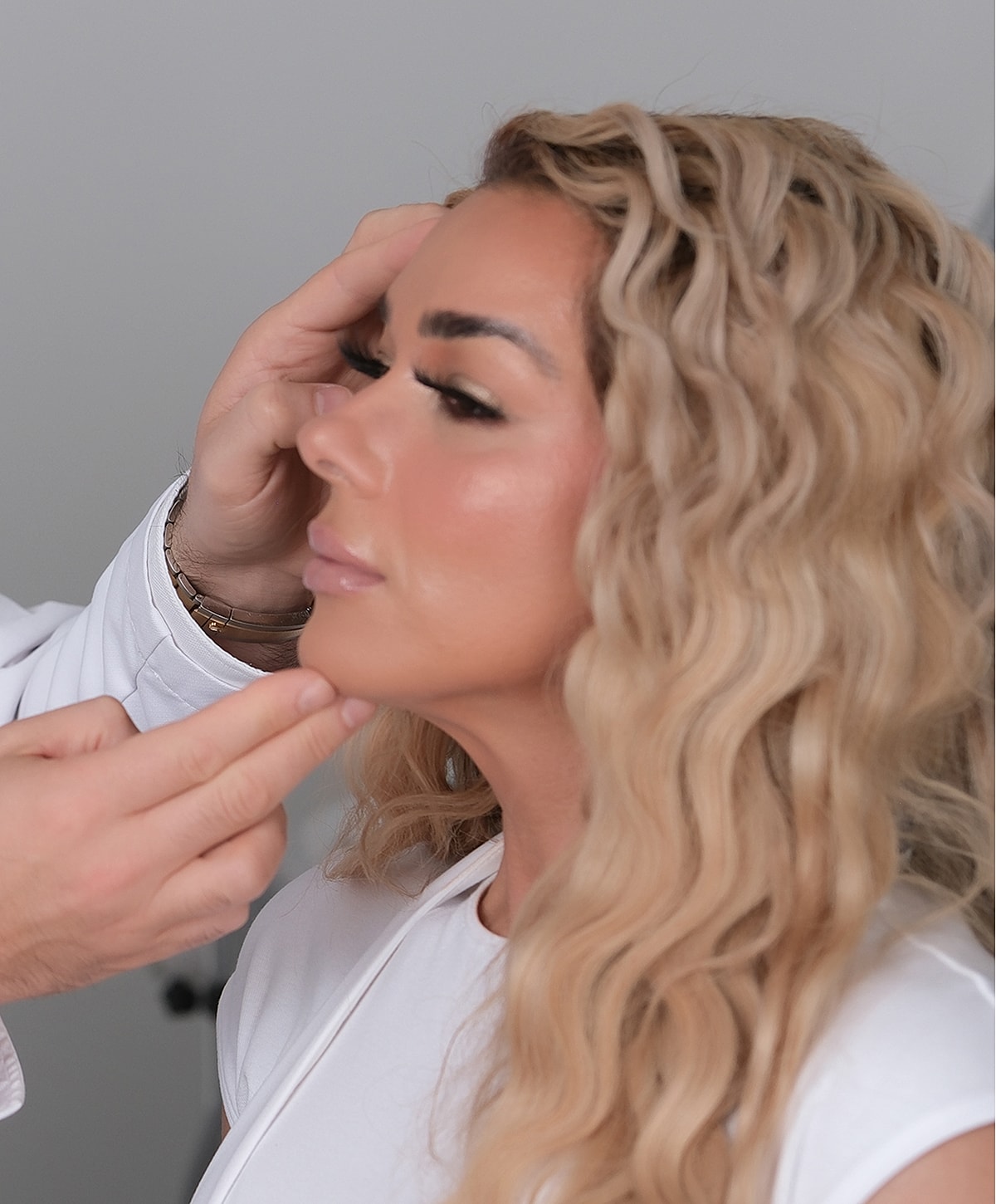 Makeup artist applying makeup on model's face.